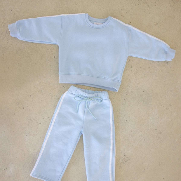 Light blue sweatshirt and pants set on a beige background
