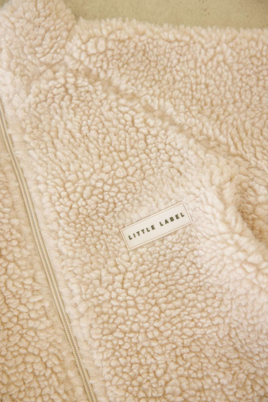 Beige fleece fabric with 'Little Label' label