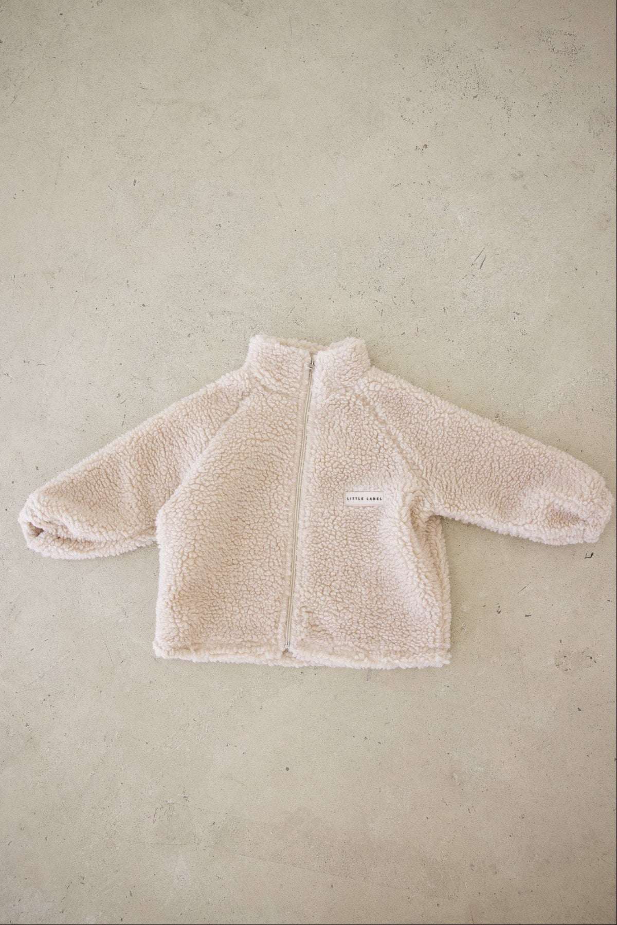 Beige fleece jacket on a beige background