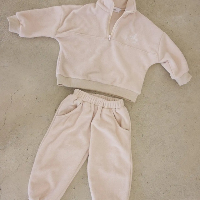 Beige fleece tracksuit on a beige textured surface
