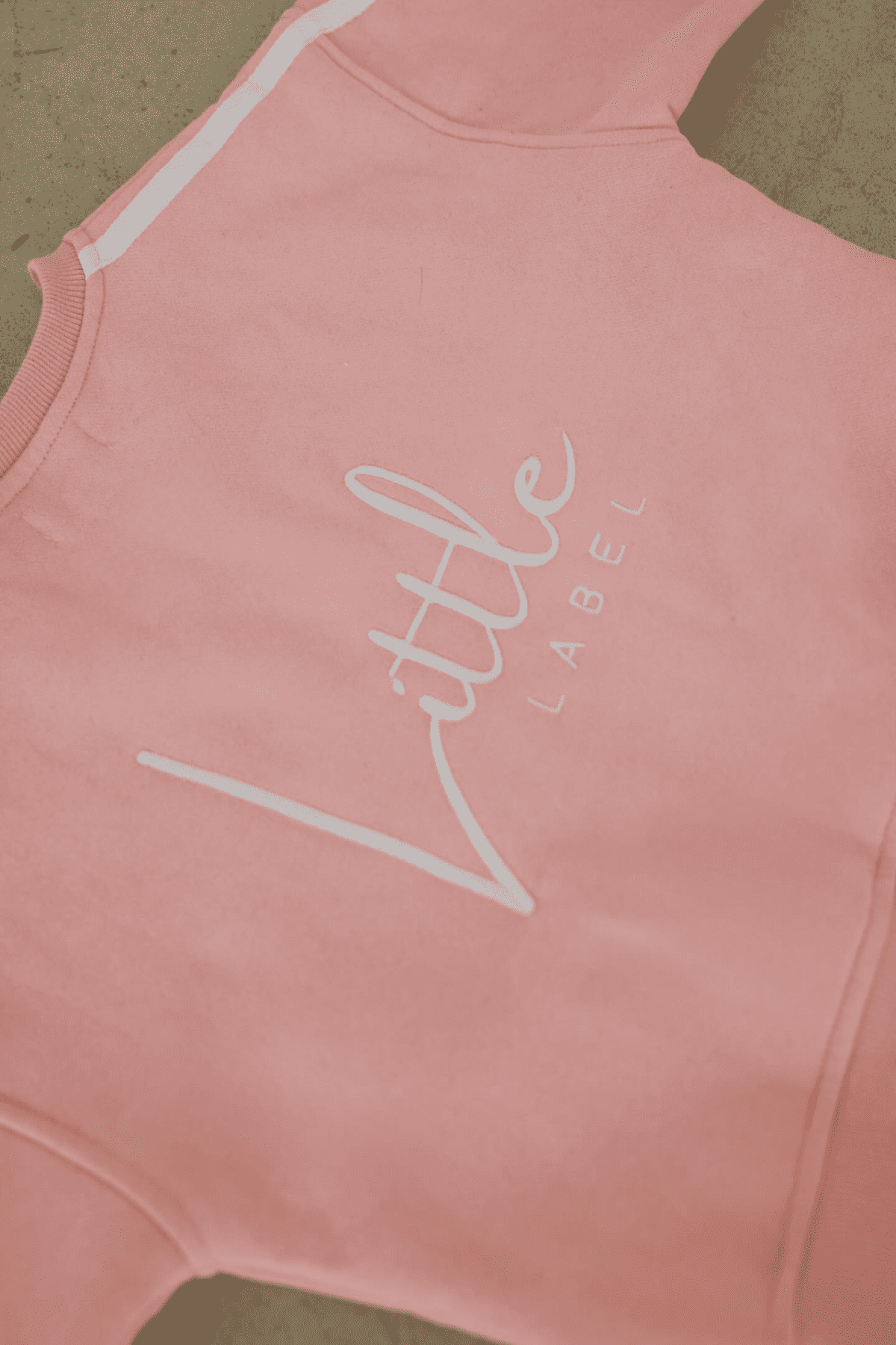 Pink sleeveless top with 'Little Label' text on a beige background