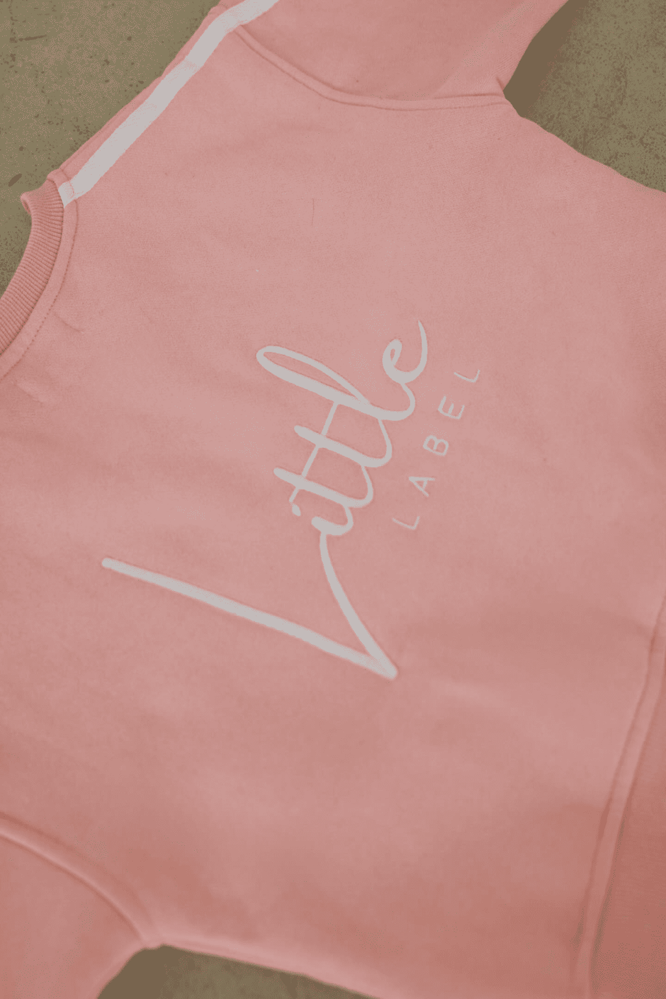Pink sleeveless top with 'Little Label' text on a beige background