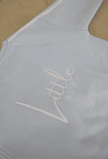 Light blue tank top with 'Little Label' logo on a beige background