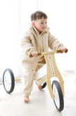 Child riding a wooden balance bike indoors | Ryan is 3'3